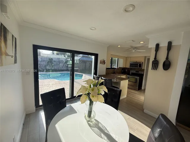 a dining room with furniture a large window and a rug