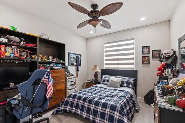 a bedroom with a bed and a flat tv screen on the dresser