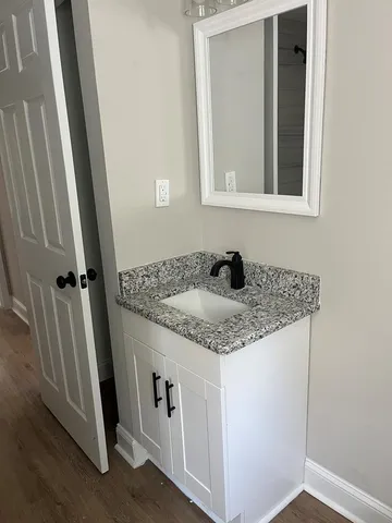 a bathroom with a granite countertop sink and vanity