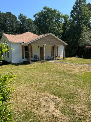 a front view of a house with yard and trees