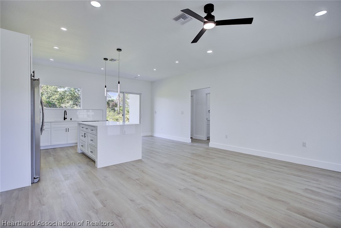 4307 Talbot Street Sebring, FL 33872 - Photo 4 of 19 an empty room with wooden floor and windows