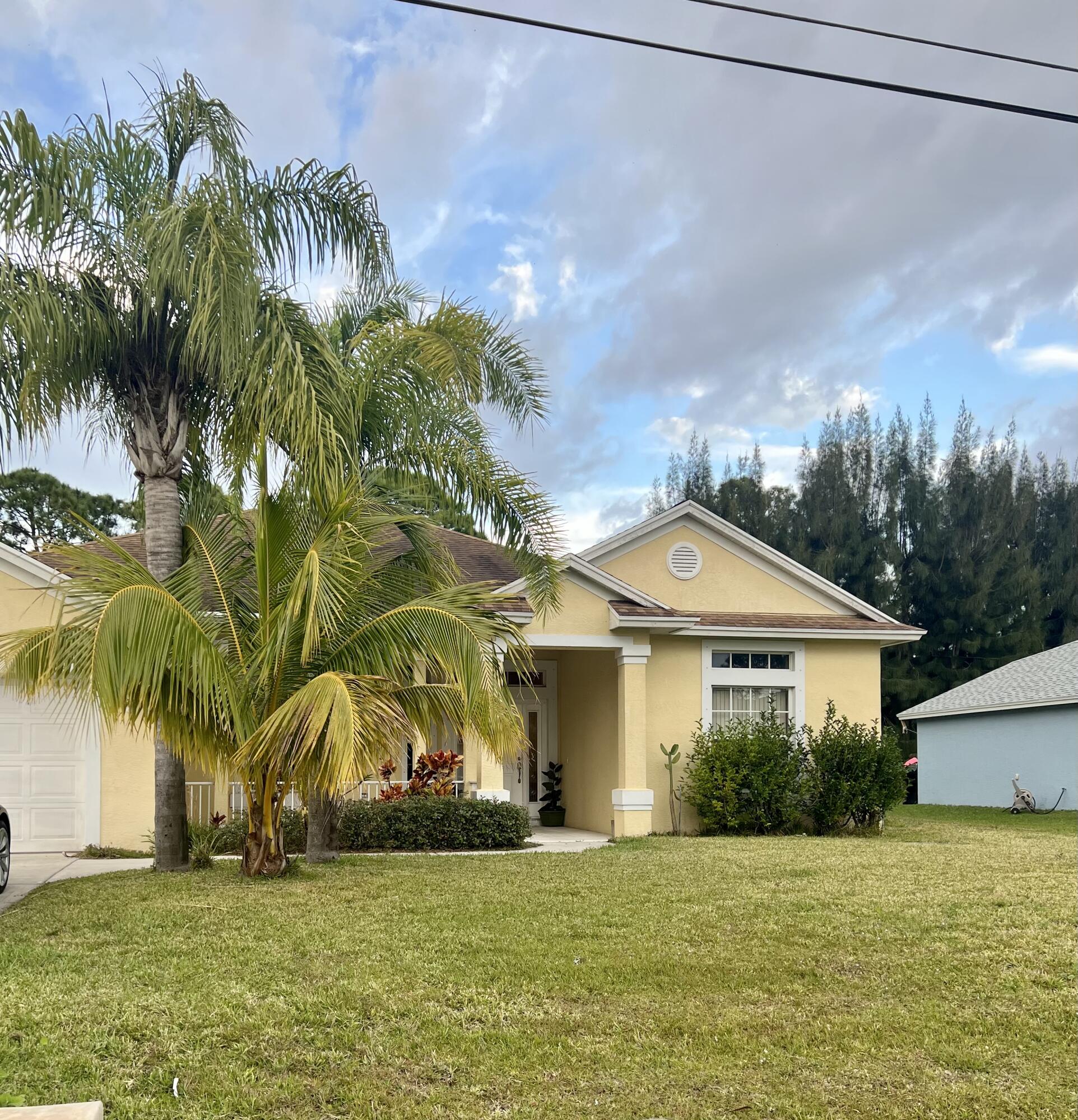 6769 Northwest Omega Road Port St. Lucie, FL 34983 - Photo 1 of 1 a front view of a house with a yard and palm trees