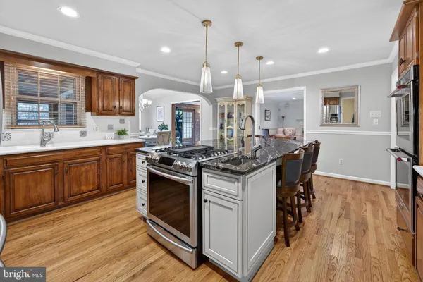 a kitchen with a sink stove and wooden floor