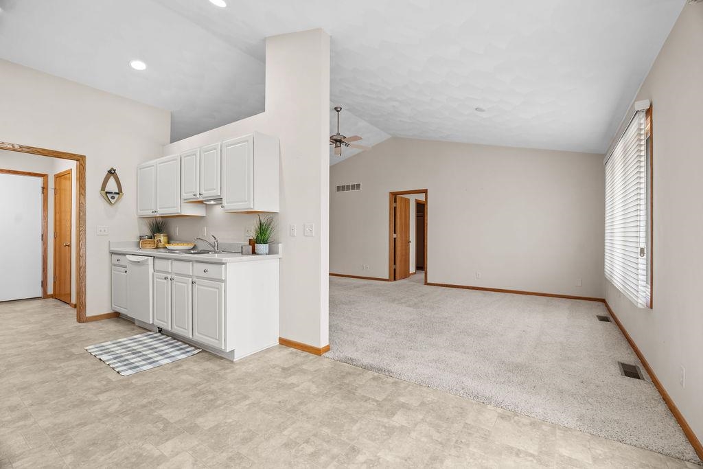 154 Rivers Edge Drive Cherry Valley, IL 61016 - Photo 11 of 32 a open kitchen with white cabinets and white appliances