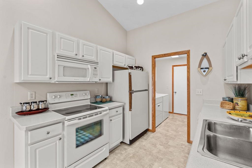 154 Rivers Edge Drive Cherry Valley, IL 61016 - Photo 13 of 32 a kitchen with white cabinets and white appliances