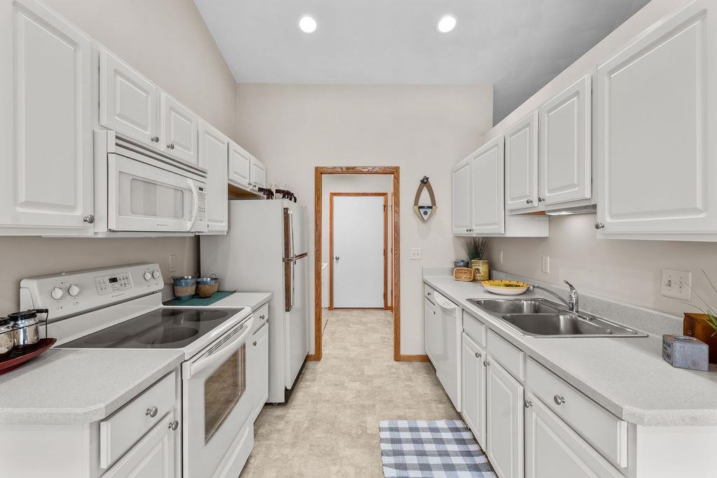154 Rivers Edge Drive Cherry Valley, IL 61016 - Photo 10 of 32 a kitchen with stainless steel appliances granite countertop a sink stove refrigerator and cabinets