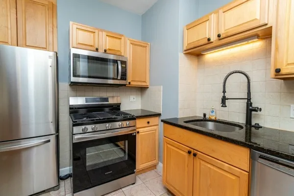 a kitchen with granite countertop a refrigerator and a stove