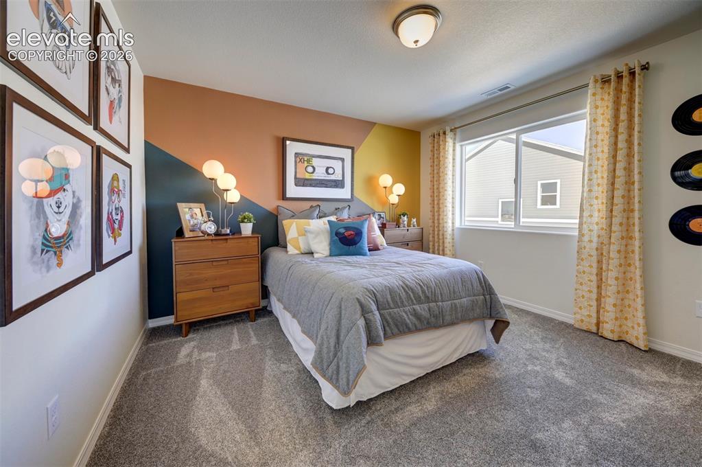 8230 Lemon Grass Road Falcon, CO 80831 - Photo 21 of 22 a spacious bedroom with a bed and a window