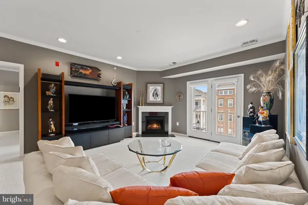 a living room with furniture a flat screen tv and a fireplace