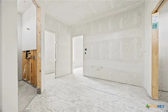 a large white room with kitchen area and fireplace