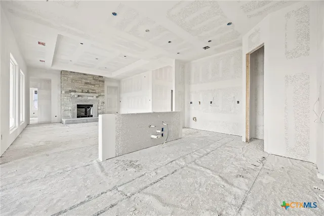 a view of empty room with fireplace and window