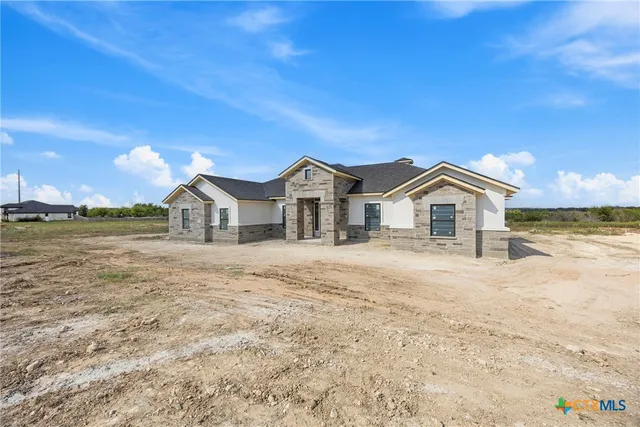 a front view of a house with cars parked
