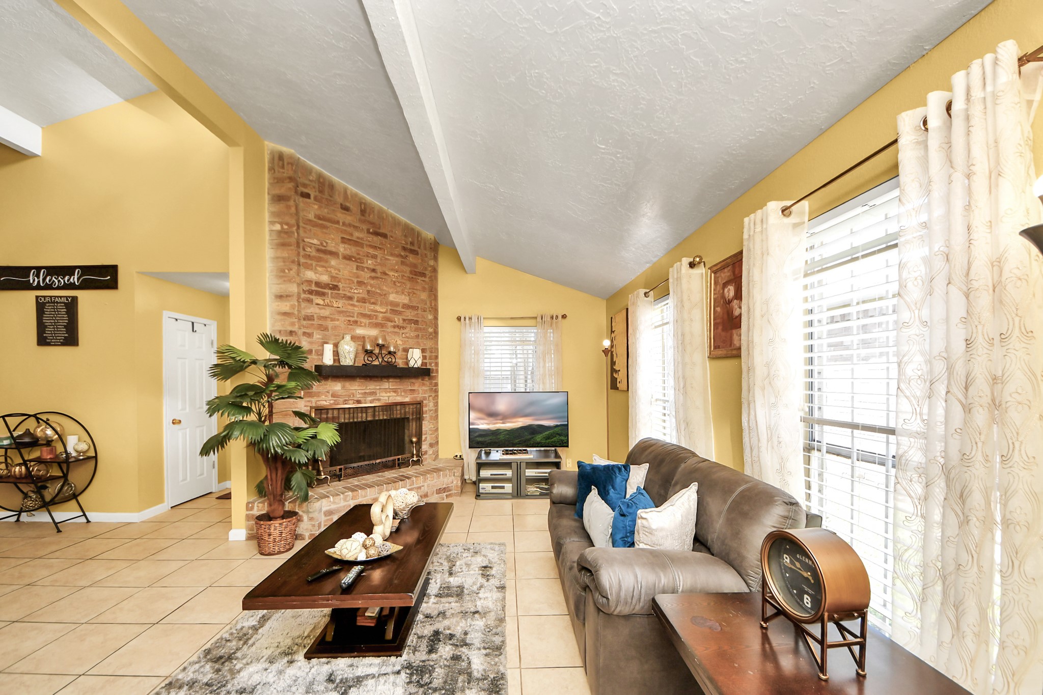 4155 Amir Street Houston, TX 77072 - Photo 13 of 43 a living room with furniture a flat screen tv and a floor to ceiling window