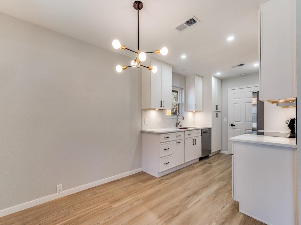 205 Laurel Street Mansfield, TX 76063 - Photo 4 of 24 a open kitchen with a sink dishwasher a stove and white countertops with wooden floor