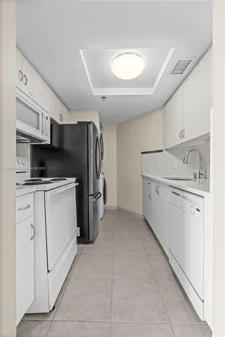a kitchen with refrigerator and cabinets
