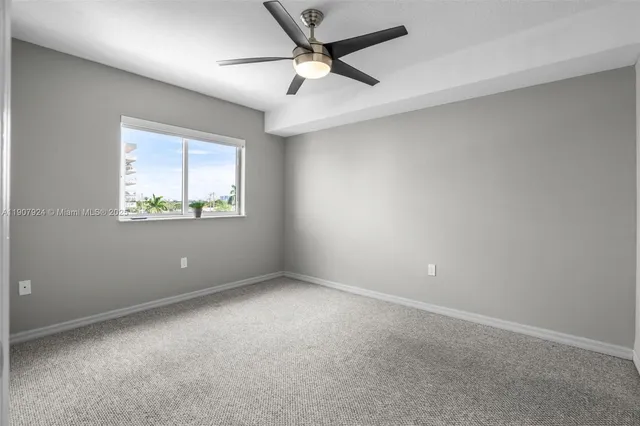 an empty room with a window and a fan