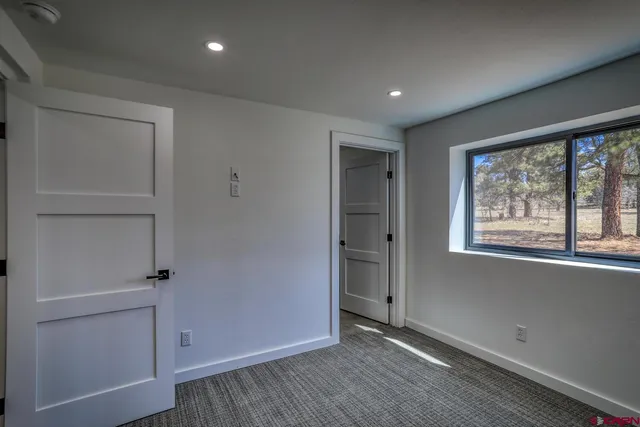 an empty room with wooden floor and window