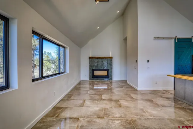 a view of an empty room with a fireplace and a window