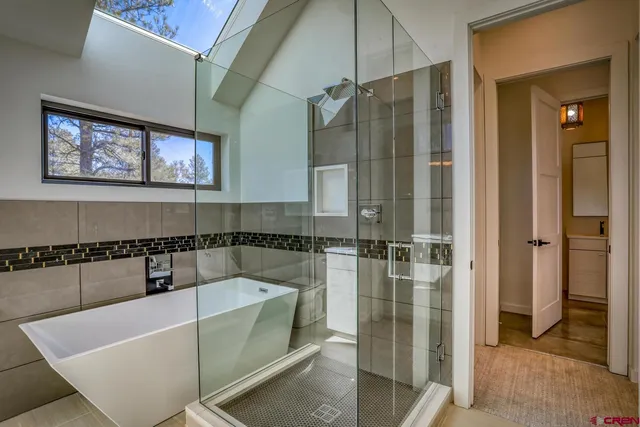 a bathroom with a tub a sink and glass door shower