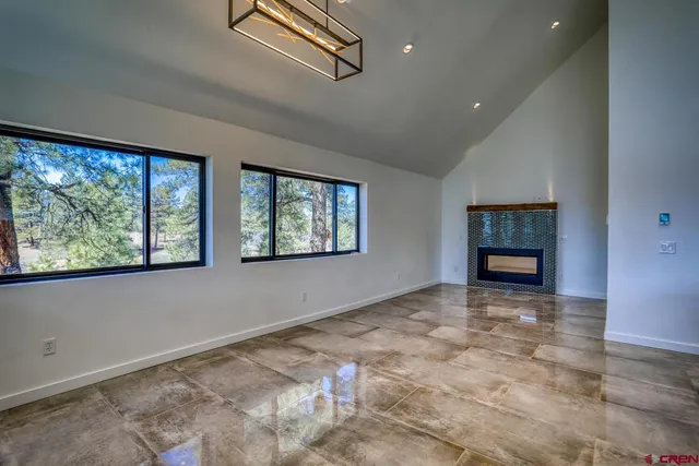 a view of an empty room with a window and fireplace