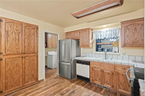 a kitchen with stainless steel appliances granite countertop a refrigerator a sink and dishwasher