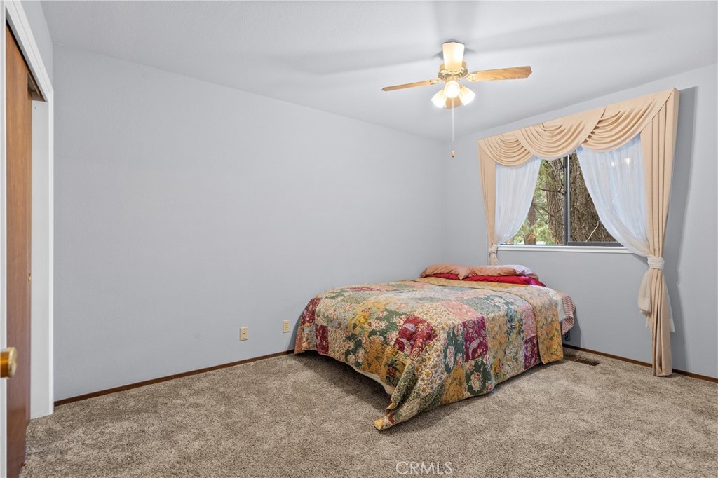 14405 Clarion Way Magalia, CA 95954 - Photo 15 of 25 a bedroom with a bed and a chandelier
