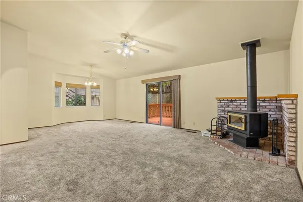 a view of an empty room with a fireplace and a window