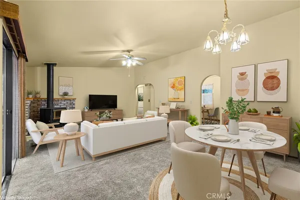 a living room with furniture a chandelier and a flat screen tv