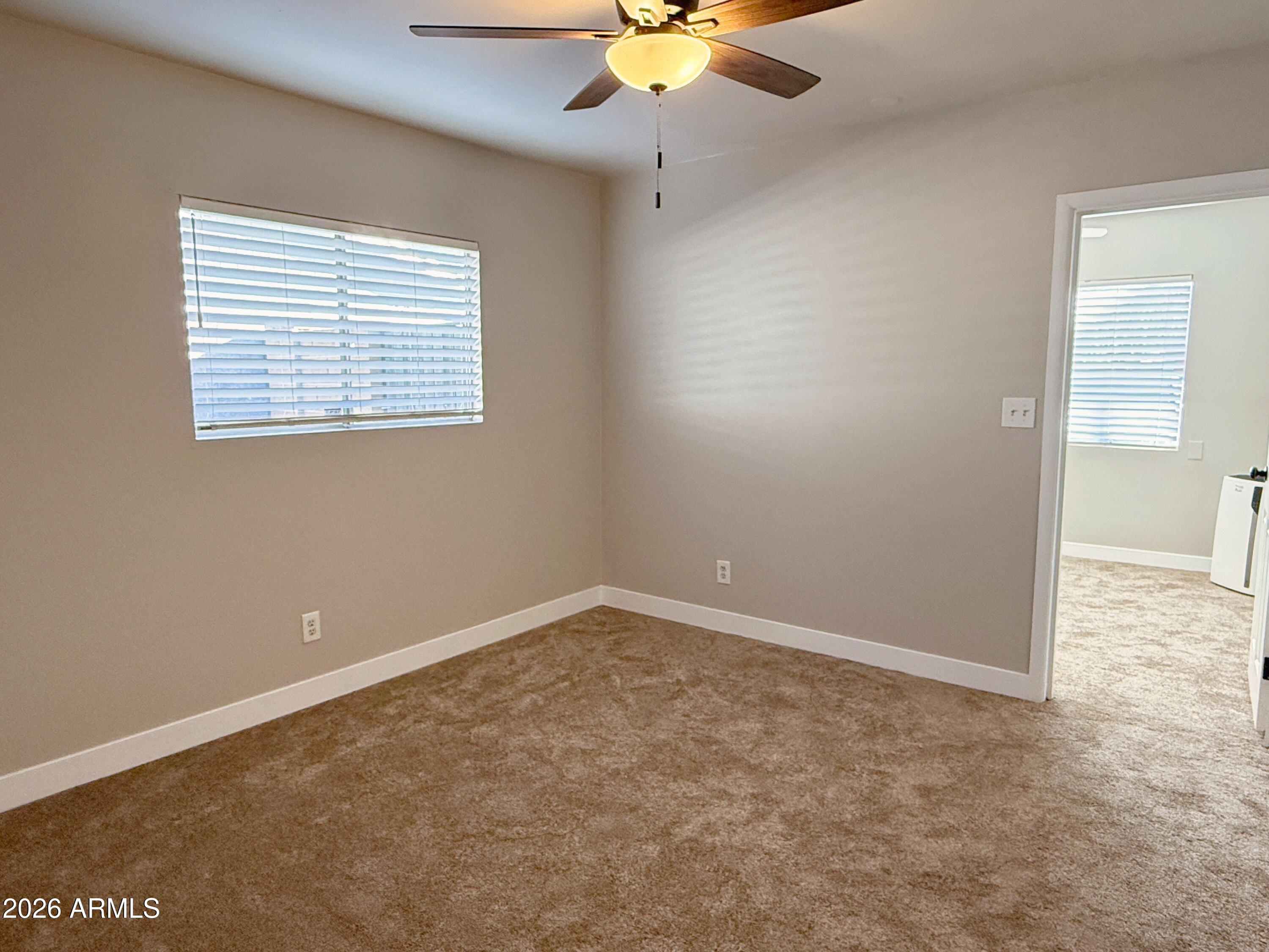 1220 West Romo Jones Street Tempe, AZ 85281 - Photo 10 of 26 an empty room with a window and a fan
