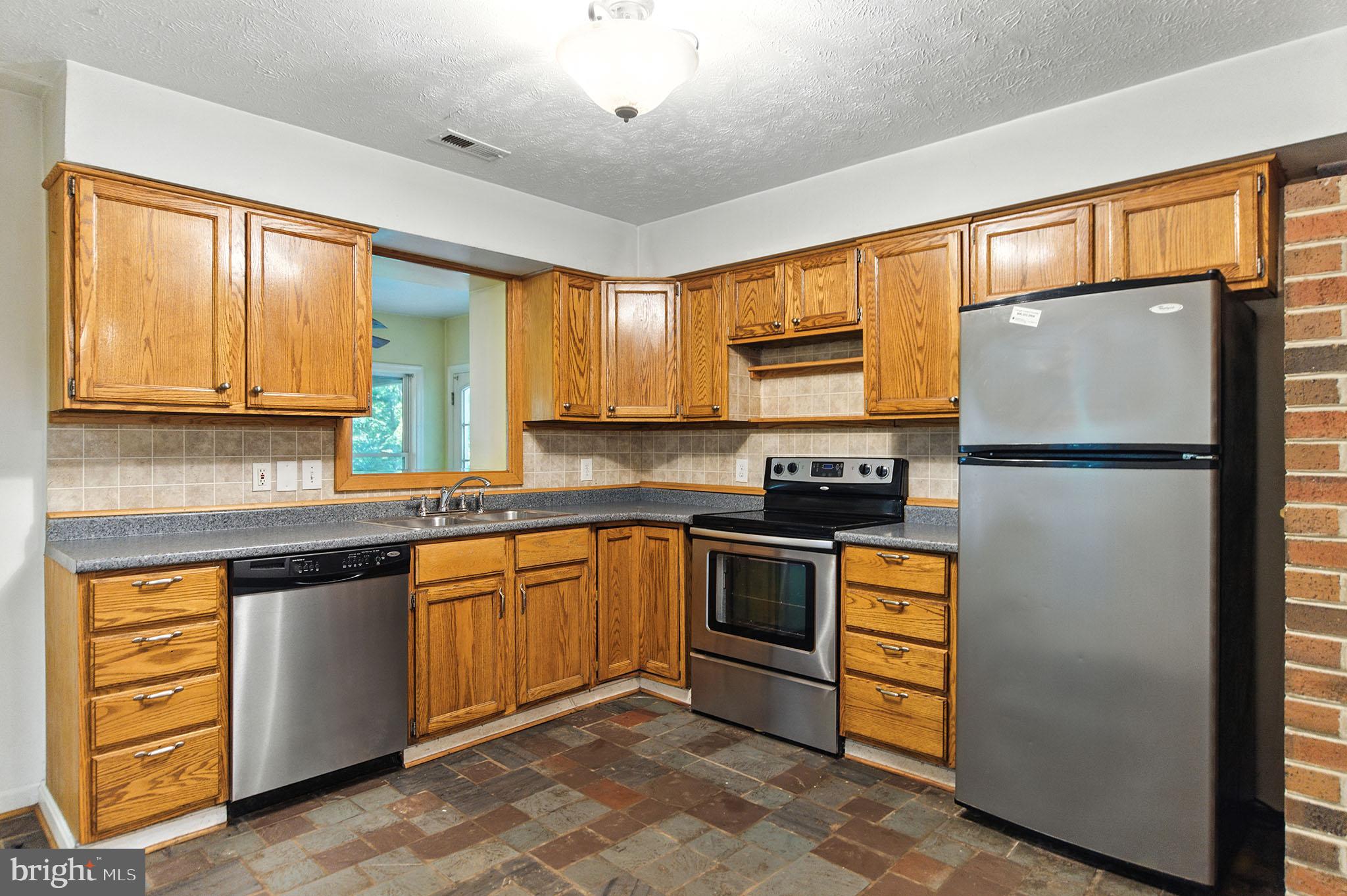 106 Inca Road Linden, VA 22642 - Photo 4 of 17 a kitchen with stainless steel appliances granite countertop a refrigerator a stove a sink and a microwave
