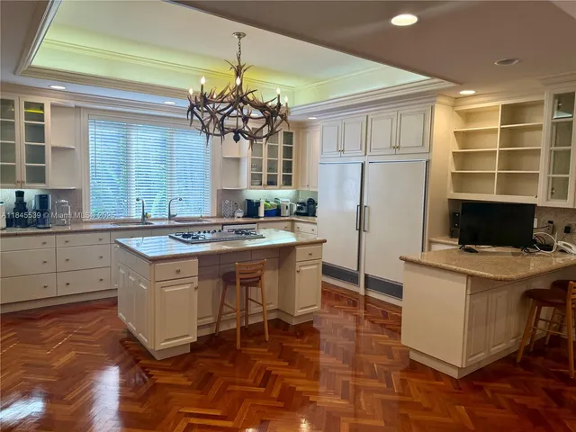 a kitchen with stainless steel appliances granite countertop a stove a sink dishwasher and white cabinets with wooden floor