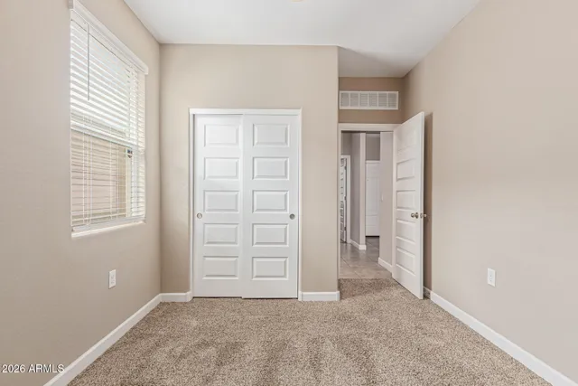 an empty room with windows and closet