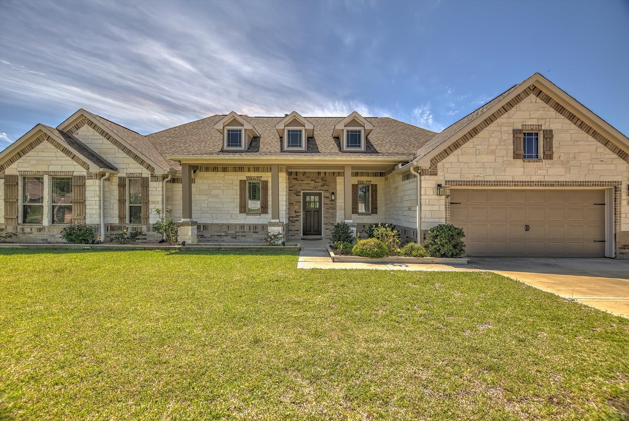 16738 Rockwall Street Conroe, TX 77303 - Photo 1 of 42 Welcome to 16738 Rockwall St. This home has a striking stone and brick exterior with a welcoming front porch and expansive driveway leading to a three-car garage.