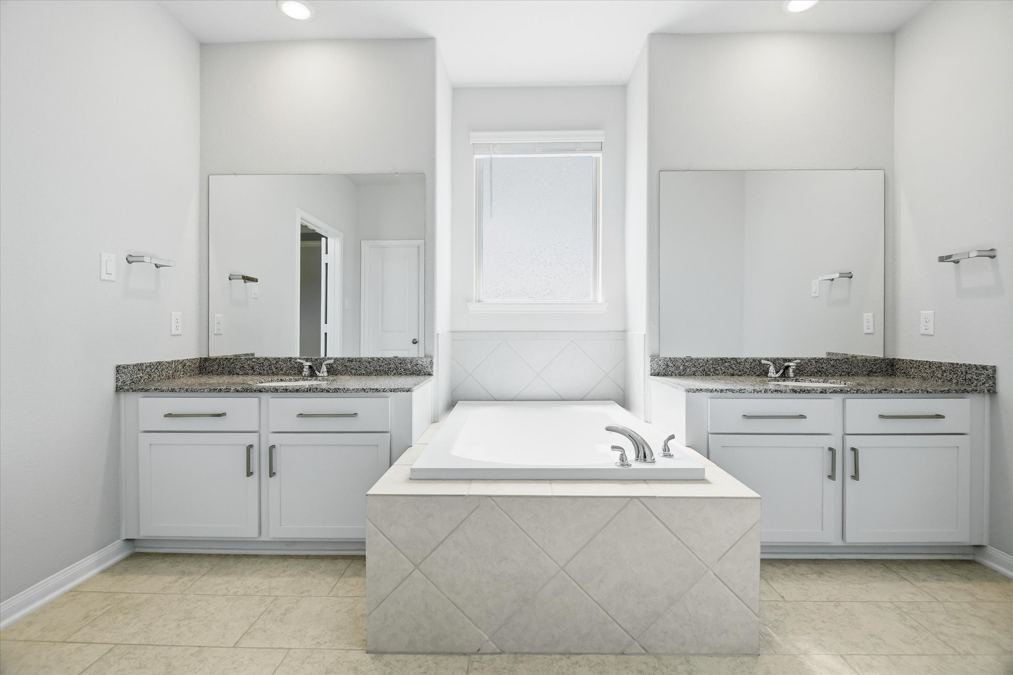 16738 Rockwall Street Conroe, TX 77303 - Photo 17 of 42 The ensuite bathroom transforms daily routines into a spa-like experience. Dual vanities provide plenty of room to spread out. A soaking tub sits perfectly positioned beneath a privacy window, inviting you to unwind at the end of the day.