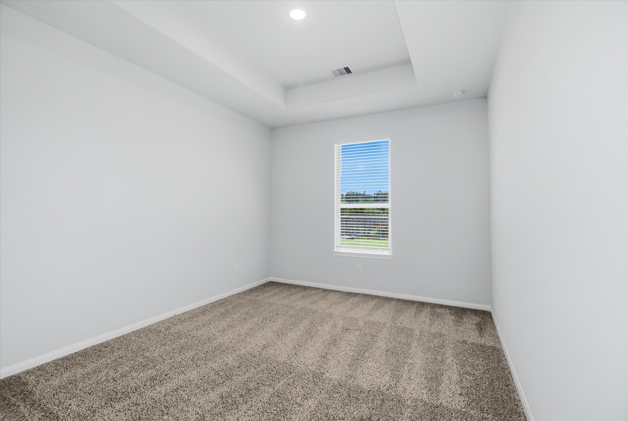 16738 Rockwall Street Conroe, TX 77303 - Photo 23 of 42 Each secondary bedroom brings its own sense of style and comfort. Tray ceilings and recessed lighting add subtle architectural detail, while windows allow natural light to fill the rooms.