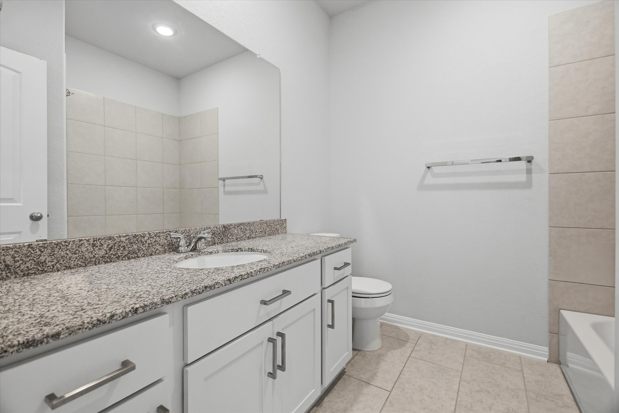 16738 Rockwall Street Conroe, TX 77303 - Photo 27 of 42 The secondary bathroom is both practical and polished. A granite countertop adds durability and style, paired with cabinetry that keeps essentials neatly stored.