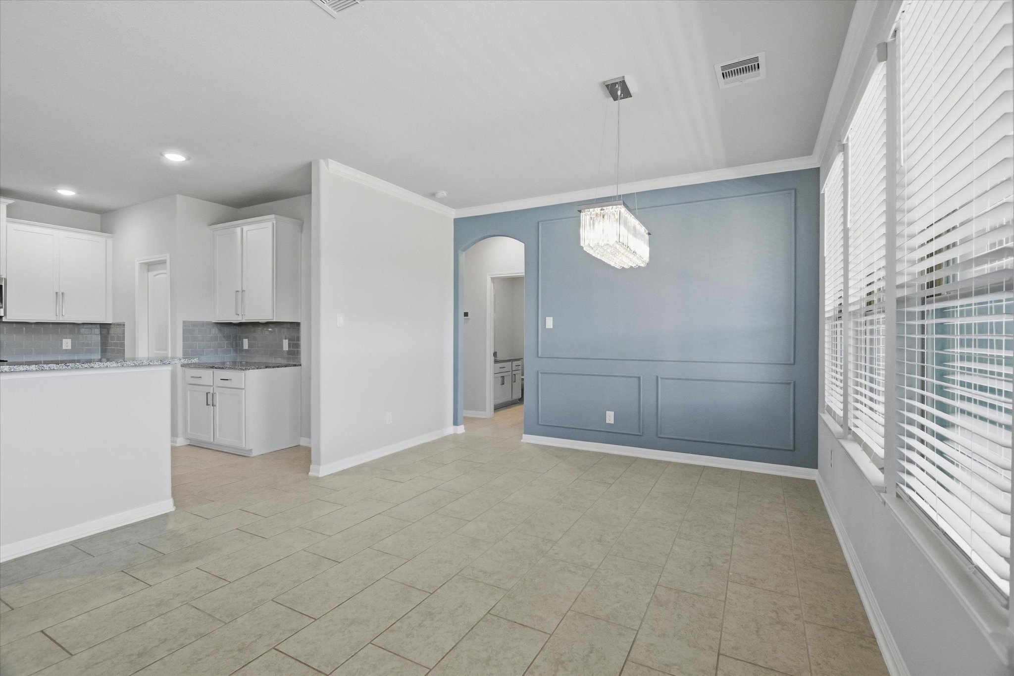 16738 Rockwall Street Conroe, TX 77303 - Photo 10 of 42 Accent wainscoting adds a layer of detail that elevates the space, while crown molding provides a refined finishing touch. A custom chandelier anchors the area, giving it personality and warmth that makes every meal feel a little more special.