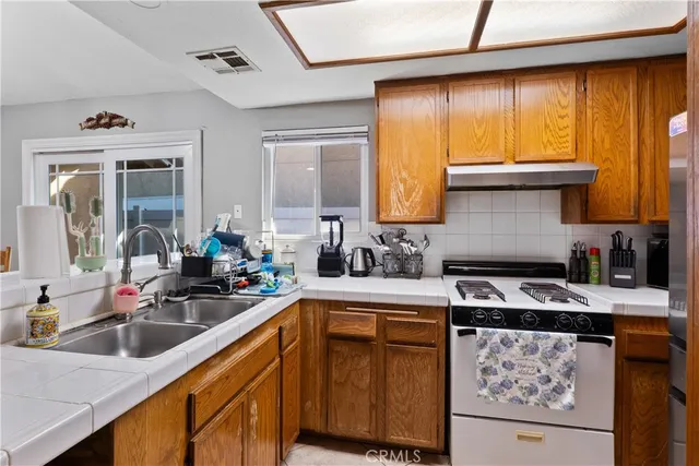a kitchen with a sink stove top oven and cabinets