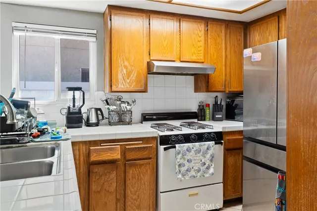 a kitchen with a stove a sink and a refrigerator