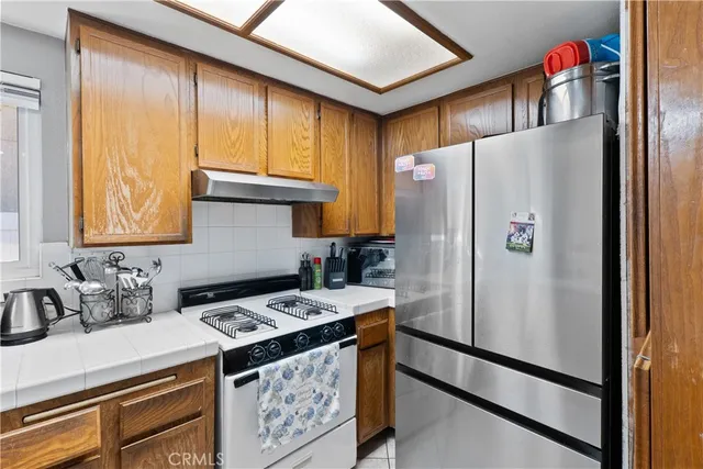 a kitchen with stainless steel appliances granite countertop a refrigerator and a stove