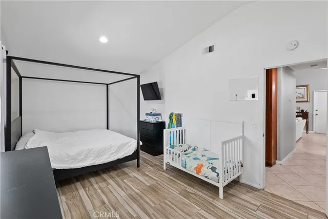 a bedroom with a bed and wooden floor