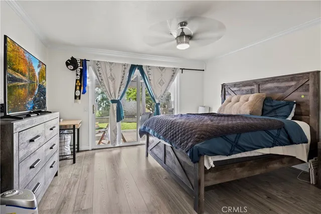 a bedroom with a large bed and a flat tv screen on dresser