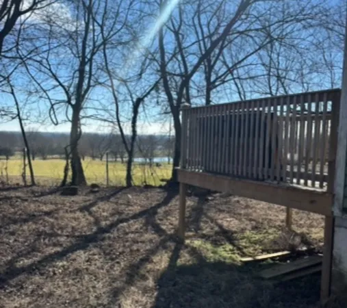 a view of a yard with wooden fence