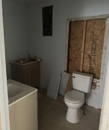 a white toilet sitting next to a bathroom sink