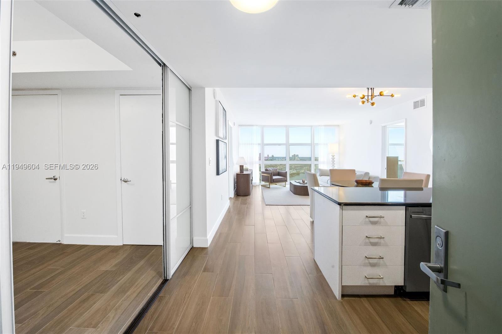 50 Biscayne Boulevard, Unit 3904 Miami, FL 33132 - Photo 2 of 21 a open kitchen with granite countertop a sink cabinets and wooden floor