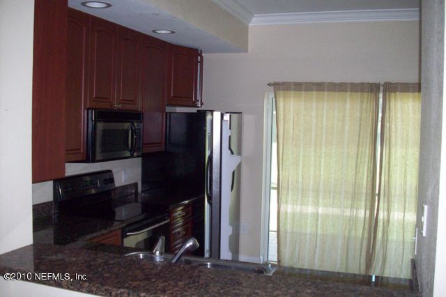 9745 Touchton Road, Unit 1701 Jacksonville, FL 32246 - Photo 2 of 12 a kitchen with a refrigerator cabinet and a microwave