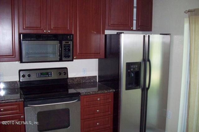 9745 Touchton Road, Unit 1701 Jacksonville, FL 32246 - Photo 3 of 12 a kitchen with stainless steel appliances granite countertop a stove microwave and refrigerator