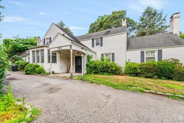 a view of a house with a yard and large tree