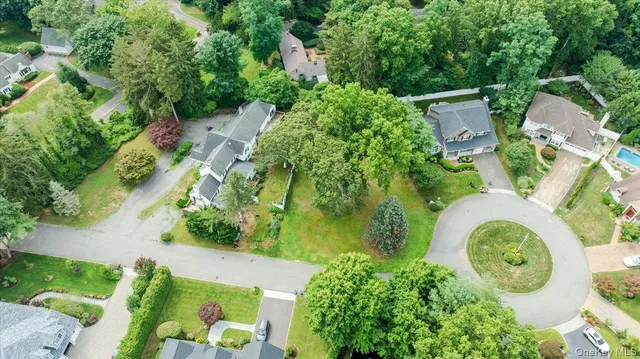 an aerial view of residential house with outdoor space and trees all around