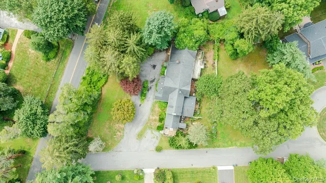 an aerial view of residential house with outdoor space and trees all around